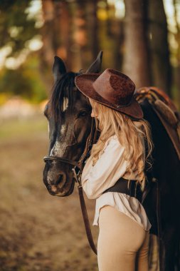 Genç ve güzel bir kadın sonbaharın başlarında atıyla ormanda yürür. Ormanda bir atla yürümek..