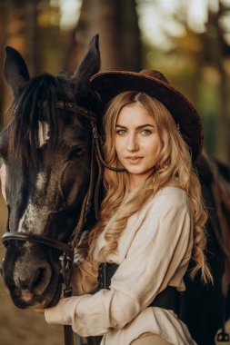 Genç ve güzel bir kadın sonbaharın başlarında atıyla ormanda yürür. Ormanda bir atla yürümek..