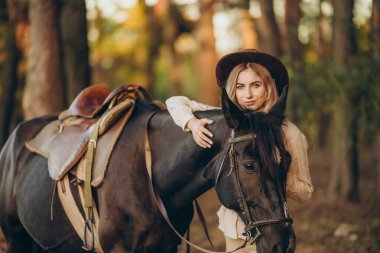 Genç ve güzel bir kadın sonbaharın başlarında atıyla ormanda yürür. Ormanda bir atla yürümek..
