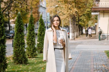 İş kadını sabah çalışmak ve kahve içmek için ofise gider. Ofise giderken sabah kahvesi..