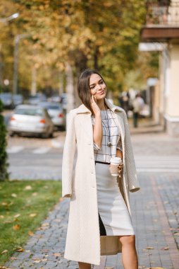 İş kadını sabah çalışmak ve kahve içmek için ofise gider. Ofise giderken sabah kahvesi..