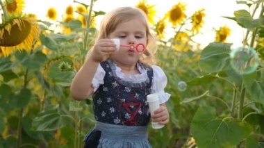 Yazın açan ayçiçeği tarlasında yürüyen küçük bir kız. Mutlu çocuklar yetiştirmek. Ayçiçeği tarlasında kızımla yürüyorum..