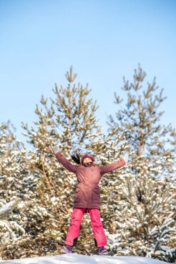 Sağlıklı bir yaşam tarzı. Aktif çocuk. Mutlu noeller. Kış parkında yürüyüş yapan bir kız. Karlı bir parkta zıplayan genç kız..