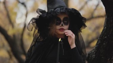 Genç kız Cadılar Bayramı için hazırlandı. Cadılar Bayramı için güzel kıyafet ve makyaj. Cadılar Bayramı arifesinde.
