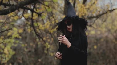 Genç kız Cadılar Bayramı için hazırlandı. Cadılar Bayramı için güzel kıyafet ve makyaj. Cadılar Bayramı arifesinde.