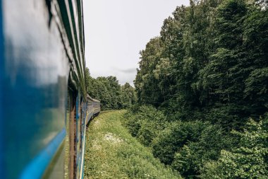 Yazın trenle dağlara seyahat et. Tren penceresinden manzara çok güzel. Yaz tatili dağlarda.