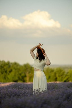 Genç bir esmer yazın günbatımında buğday tarlalarında yürür. Organik buğday ve arpa yetiştiriyor..