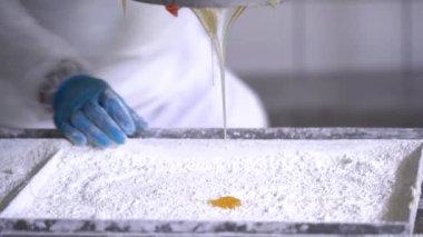 Türk lokum tankından Türk lokum fabrikasındaki tepsilere şam fıstığı döküldü. Şekerleme fabrikası, Türk lokum atölyesi üretimi. 4K Video çekimi.