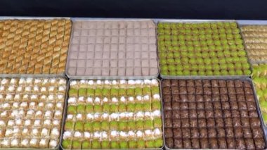 Tepsilerde Türk baklavası, burma kadayif, sobiyet, sutlu nuriye, çikolata baklava, Türk geleneksel Şerbeti tatlıları 4K Video çekimi.