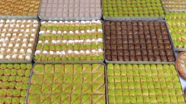 Tepsilerde Türk baklavası, burma kadayif, sobiyet, sutlu nuriye, çikolata baklava, Türk geleneksel Şerbeti tatlıları 4K Video çekimi.