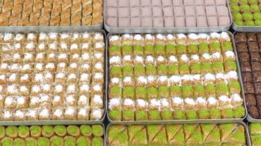Tepsilerde Türk baklavası, burma kadayif, sobiyet, sutlu nuriye, çikolata baklava, Türk geleneksel Şerbeti tatlıları 4K Video çekimi.