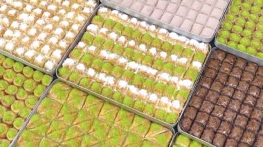 Tepsilerde Türk baklavası, burma kadayif, sobiyet, sutlu nuriye, çikolata baklava, Türk geleneksel Şerbeti tatlıları 4K Video çekimi.