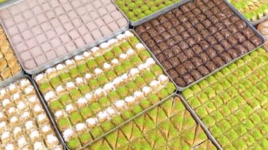 Tepsilerde Türk baklavası, burma kadayif, sobiyet, sutlu nuriye, çikolata baklava, Türk geleneksel Şerbeti tatlıları 4K Video çekimi.