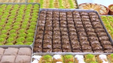 Tepsilerde Türk baklavası, burma kadayif, sobiyet, sutlu nuriye, çikolata baklava, Türk geleneksel Şerbeti tatlıları 4K Video çekimi.