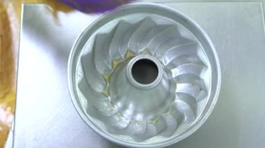 Yiyecek fabrikasındaki pasta kalıplarına ahudududulu kek hamuru döküyorum. Lezzetli pasta üretim süreci. 4K video yakalama.