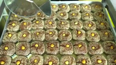 Tatlı üretim fabrikasında sekerpare tatlı üretimi. Tepside lezzetli Türk usulü tatlı sekerpare. Türk Ramazanı tatlı Sekerpare. 4K video çekimi.