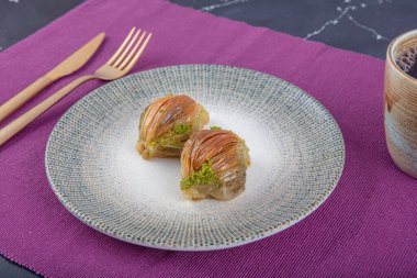 Bir dilim midye baklavası. Seramik tabakta fıstıklı midye şeklinde özel Türk baklavası. İslami Kurban Konsepti.