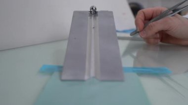 Kalite kontrolü, koli bandı üretim fabrikasındaki laboratuvarda yapılır. Amerikan standart 14 numaralı çelik top bandı ilk yapışma testi, ilk yapışma. Yavaş Çekim.