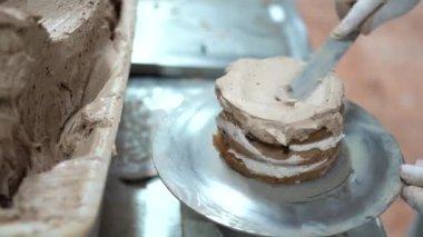Pasta şefi, ticari mutfakta taze çikolatalı pasta yapıyor. Pastayı yapmak için son adım. Fabrikadaki pastanın tamamlanması. Şekerleme fabrikası. Yüksek kalite 4K görüntü.