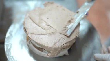 Pasta şefi, ticari mutfakta taze çikolatalı pasta yapıyor. Pastayı yapmak için son adım. Fabrikadaki pastanın tamamlanması. Şekerleme fabrikası. Yüksek kalite 4K görüntü.