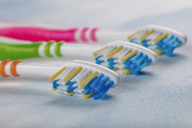 Renkli arka planda renkli saplı plastik diş fırçaları.