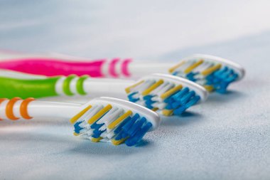 Renkli arka planda renkli saplı plastik diş fırçaları.