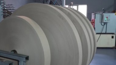 Karton bobbin yapımı. Kağıt yapma makinesi eski bir kombinatta teknik karton üretiyor. Kağıt ve kağıt fabrikası. Yüksek kalite 4K video çekimi.