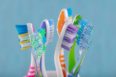 Diş fırçaları seramik kasede bulanık arka planda. Renkli diş fırçaları, sağlıklı diş fırçaları..