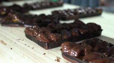 Üretim hattında bir sürü tatlı krema pişiriyor. tatlı yemek konsepti. Yeni pişmiş, çıtır çıtır, dikdörtgen ekler. Geleneksel Fransız ekleriymiş. Kalite 4K video yakalama.