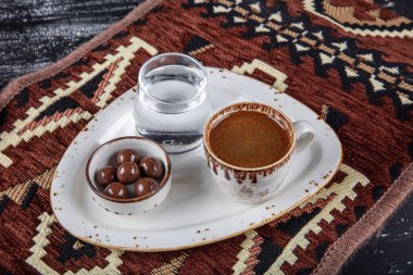 Geleneksel Türk kahvesi porselen bardakta, ahşap masada. Anadolu Geleneksel Sıcak ve Lezzetli Türk Kahvesi.