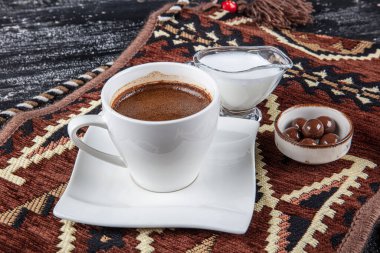 Geleneksel Türk kahvesi porselen bardakta, ahşap masada. Anadolu Geleneksel Sıcak ve Lezzetli Türk Kahvesi.