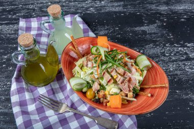 Dünya mutfağı tavuk salatası. Koyu mutfak masasında fırında tavuk göğsü ile yeşil salata. Sağlıklı yiyecekler, temiz yeme konsepti. 