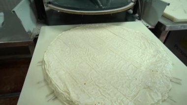 Food Factory otomatikman fillo hamur üretiyor. Hamur taşıyıcı, fillo ekmeği pişirme işlemi. 4K kalite video çekimi. Geleneksel, fillo hamuru (buğday unundan yapılır). yerel isim; Yufka.