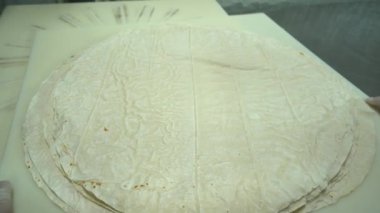 Food Factory otomatikman fillo hamur üretiyor. Hamur taşıyıcı, fillo ekmeği pişirme işlemi. 4K kalite video çekimi. Geleneksel, fillo hamuru (buğday unundan yapılır). yerel isim; Yufka.