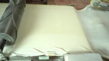 Food Factory otomatikman fillo hamur üretiyor. Hamur taşıyıcı, fillo ekmeği pişirme işlemi. 4K kalite video çekimi. Geleneksel, fillo hamuru (buğday unundan yapılır). yerel isim; Yufka.