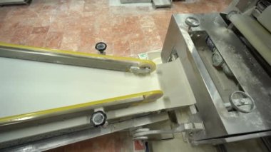 Food Factory otomatikman fillo hamur üretiyor. Hamur taşıyıcı, fillo ekmeği pişirme işlemi. 4K kalite video çekimi. Geleneksel, fillo hamuru (buğday unundan yapılır). yerel isim; Yufka.