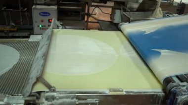 Food Factory otomatikman fillo hamur üretiyor. Hamur taşıyıcı, fillo ekmeği pişirme işlemi. 4K kalite video çekimi. Geleneksel, fillo hamuru (buğday unundan yapılır). yerel isim; Yufka.