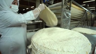 Food Factory otomatikman fillo hamur üretiyor. Hamur taşıyıcı, fillo ekmeği pişirme işlemi. 4K kalite video çekimi. Geleneksel, fillo hamuru (buğday unundan yapılır). yerel isim; Yufka.