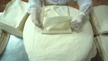 Food Factory otomatikman fillo hamur üretiyor. Hamur taşıyıcı, fillo ekmeği pişirme işlemi. 4K kalite video çekimi. Geleneksel, fillo hamuru (buğday unundan yapılır). yerel isim; Yufka.