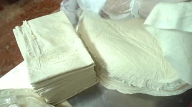 Food Factory otomatikman fillo hamur üretiyor. Hamur taşıyıcı, fillo ekmeği pişirme işlemi. 4K kalite video çekimi. Geleneksel, fillo hamuru (buğday unundan yapılır). yerel isim; Yufka.