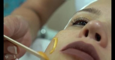 Kozmetik kliniğindeki genç bir kadının parlak yüz derisi. Modern insanlar için profesyonel nemlendirici, gençleştirici donanım prosedürleri. Güzel bir kadın kaplıcada uzanıyor ve yüz bakımı yaptırıyor..
