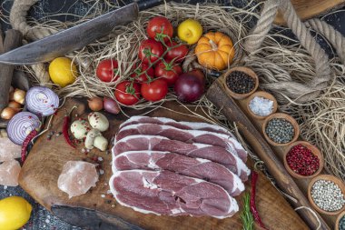 Baharatlı çiğ biftek. Arka planda organik kırmızı sığır filetosu.