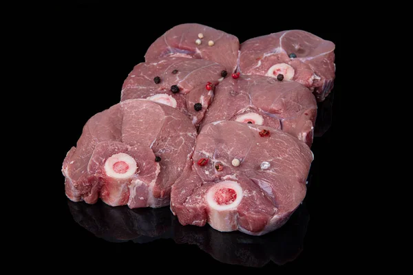 Raw lamb shanks meat, Raw lamb leg (Turkish name; kuzu incik). Fresh raw meat of leg young lamb. Raw lamb leg on marble stone background with herbs. Isolated on black background