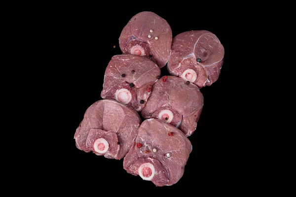 Raw lamb shanks meat, Raw lamb leg (Turkish name; kuzu incik). Fresh raw meat of leg young lamb. Raw lamb leg on marble stone background with herbs. Isolated on black background
