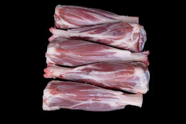 Fresh raw meat of lamb leg. Raw lamb leg isolated on black background. ossobuco (lamb shank steak with bones).