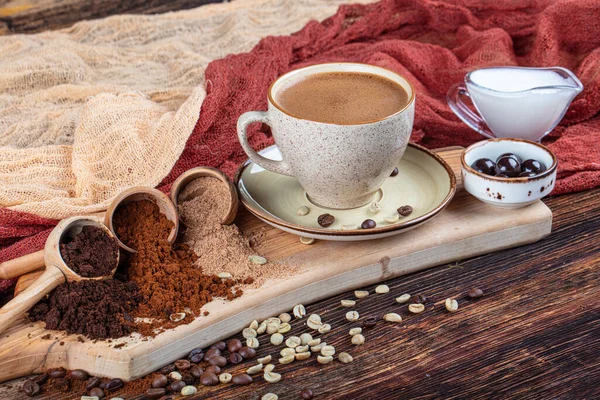 Traditional Turkish coffee beverage concept. Fresh and delicious Turkish coffee presentation. Double Turkish coffee, various roasted and ground coffee beans in wooden spoons.