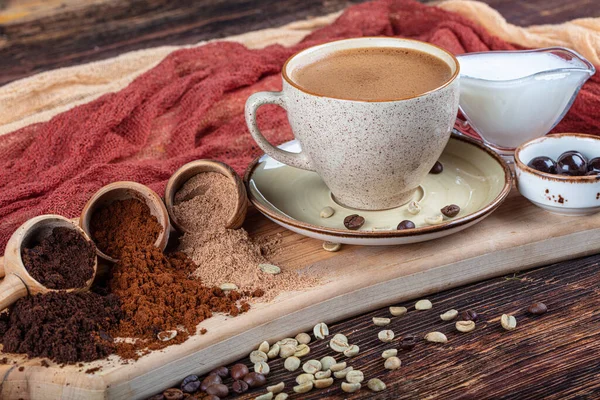 Traditional Turkish coffee beverage concept. Fresh and delicious Turkish coffee presentation. Double Turkish coffee, various roasted and ground coffee beans in wooden spoons.