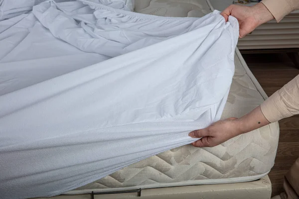 Corner of the sheet with sewn-in elastic band for a good fit on the mattress and a comfortable sleep. White fabric for mockup overlay design. Home textiles for the bedroom. Bedspread mattress.
