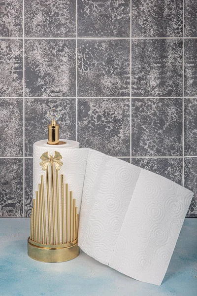 Kitchen and Bathroom paper towels on holder.Rolling paper towel standing holder on blue wooden background.