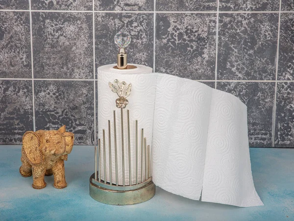 Kitchen and Bathroom paper towels on holder.Rolling paper towel standing holder on blue wooden background.
